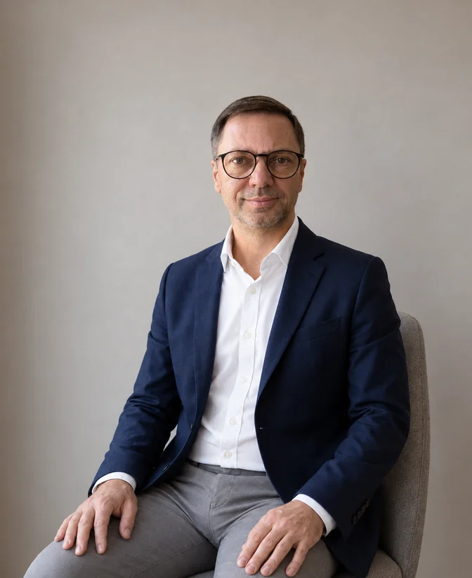 Bartłomiej Przytuła, mentor biznesowy, coach i psycholog, siedzi w fotelu i patrzy w obiektyw